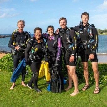 a group of people standing next to a body of water