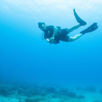 a man flying through the air while swimming in a body of water