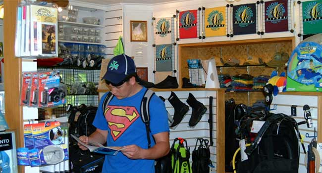 Ready for Adventure – Scuba Gear Preparation in Kauai Person holding a scuba diving kit in a shop in Kauai, Hawaii.