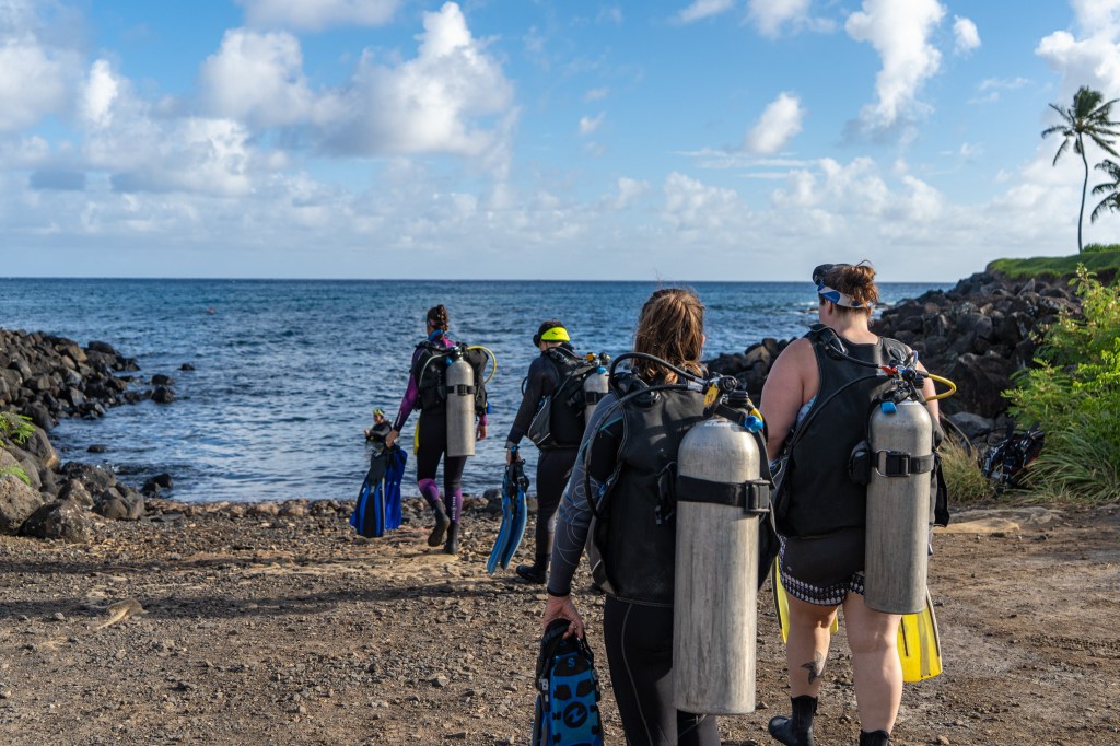 a group of people standing on top of a Koloa Ranch