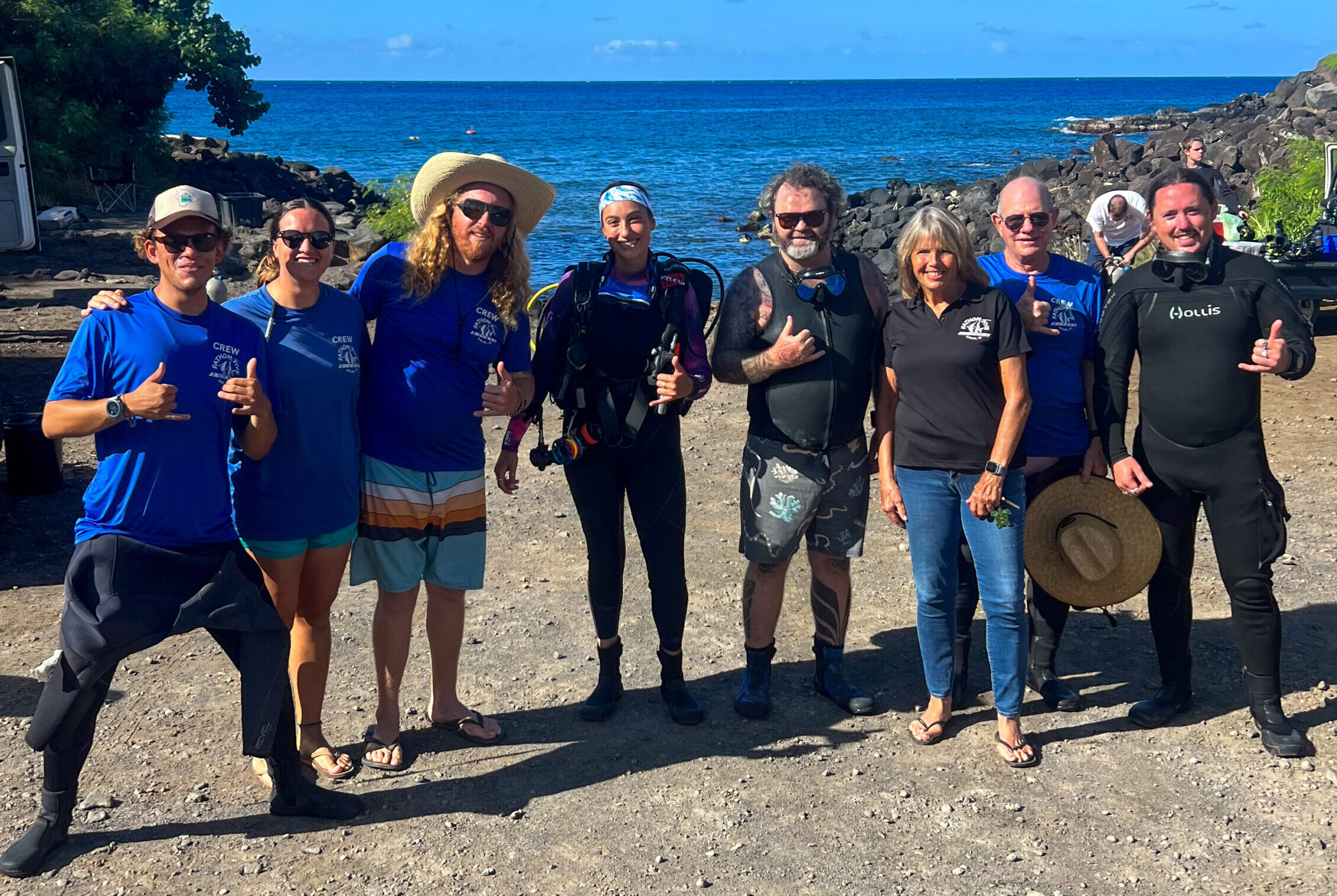a group of people standing on a beach posing for the camera
